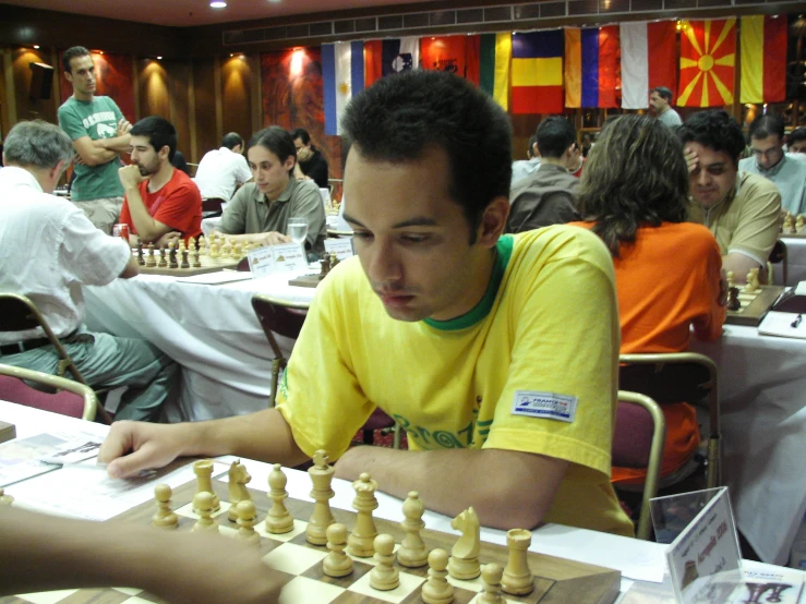 a man sitting at a table while playing chess