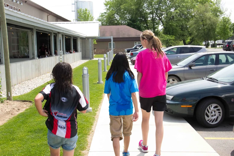 two girls are walking on the sidewalk together