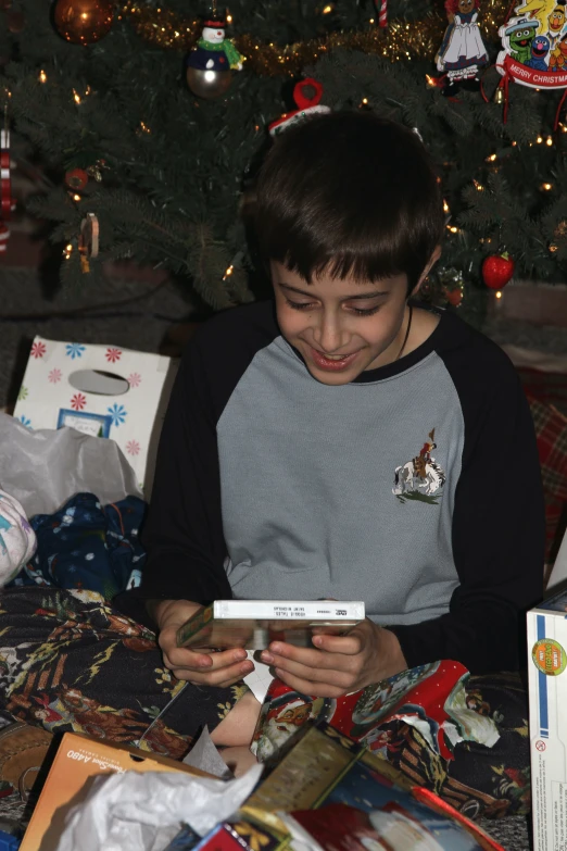 a boy wearing a black and grey shirt playing with a remote control