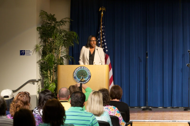 a person standing at a podium addressing an audience