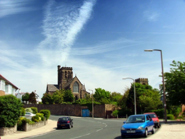 cars drive on a street in front of a church