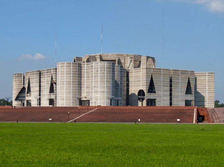 a big building sits in the middle of some grass