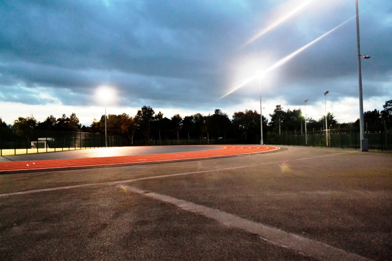 an empty tennis court is pictured at night