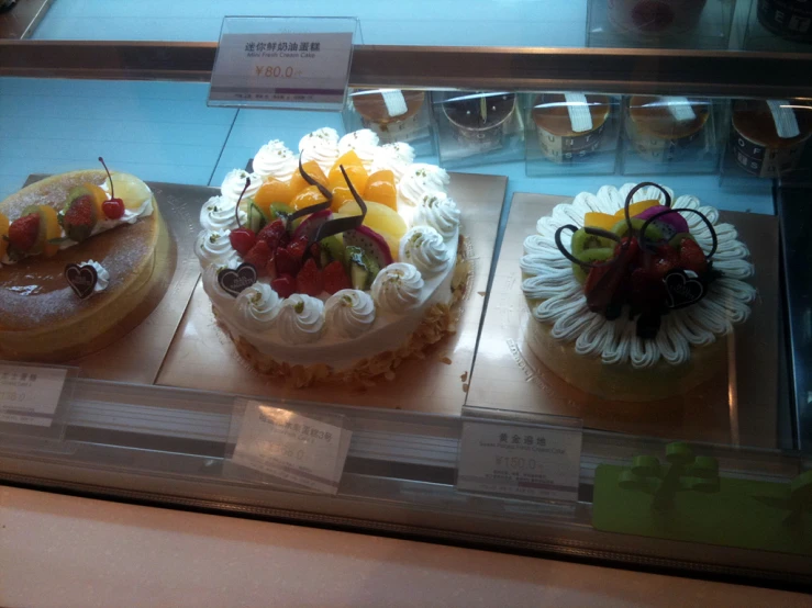 a display case filled with four cakes on top of it