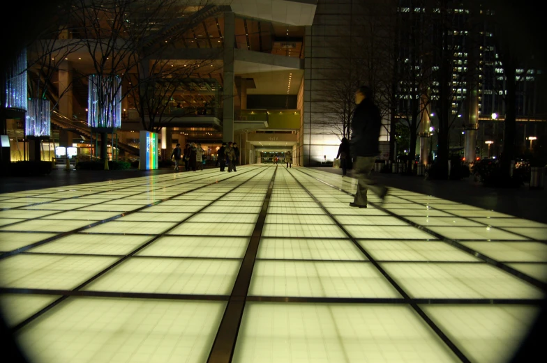 lighted tiled walkway in city with people in the background