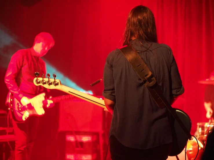 two people standing on stage with a guitar