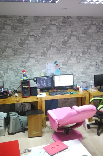 there are desks and computer monitors in the room