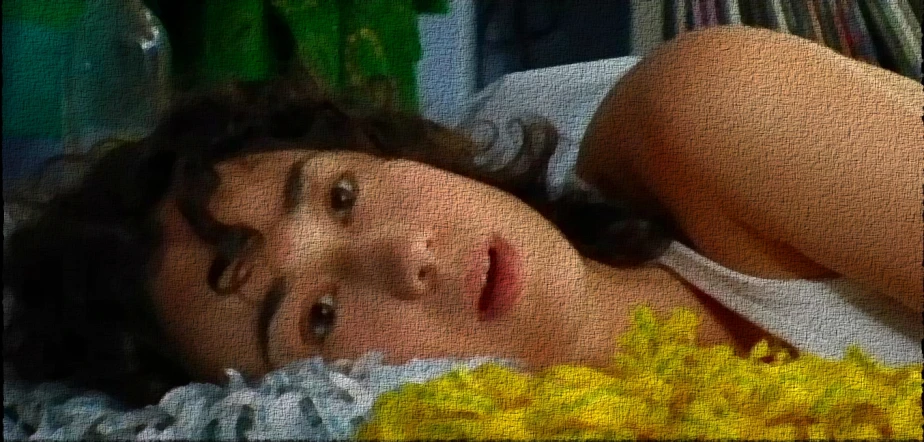 a close up of a woman in white top laying in a bed