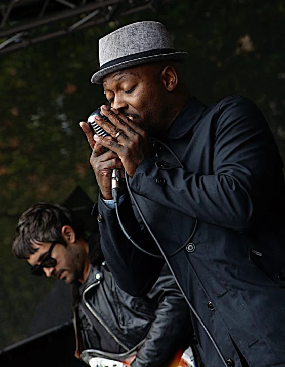 two men with hats and instruments are on stage