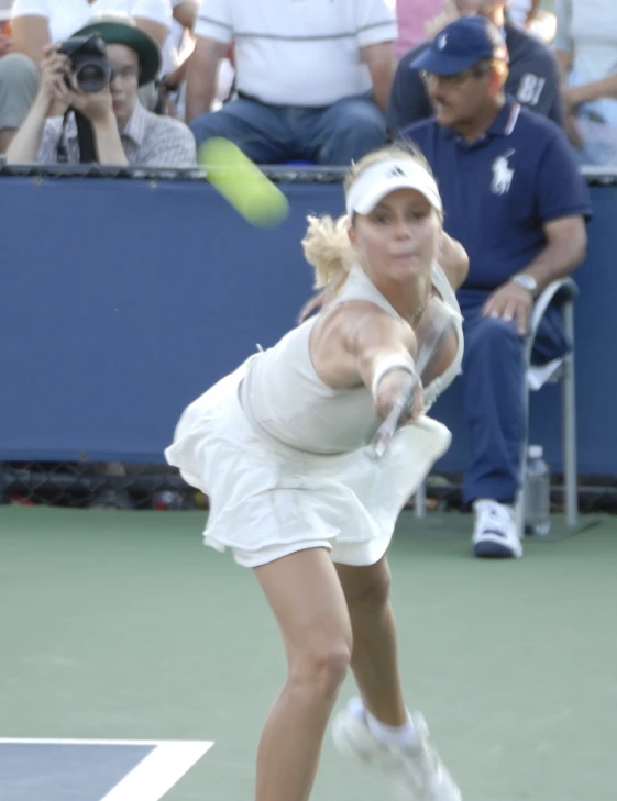 the woman is swinging her tennis racket at the ball