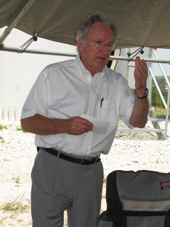 man is using a cell phone under a tent