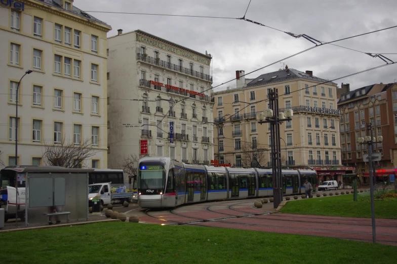 a train is passing on tracks next to buildings