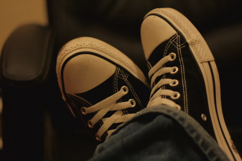 an adult's feet wearing black sneakers
