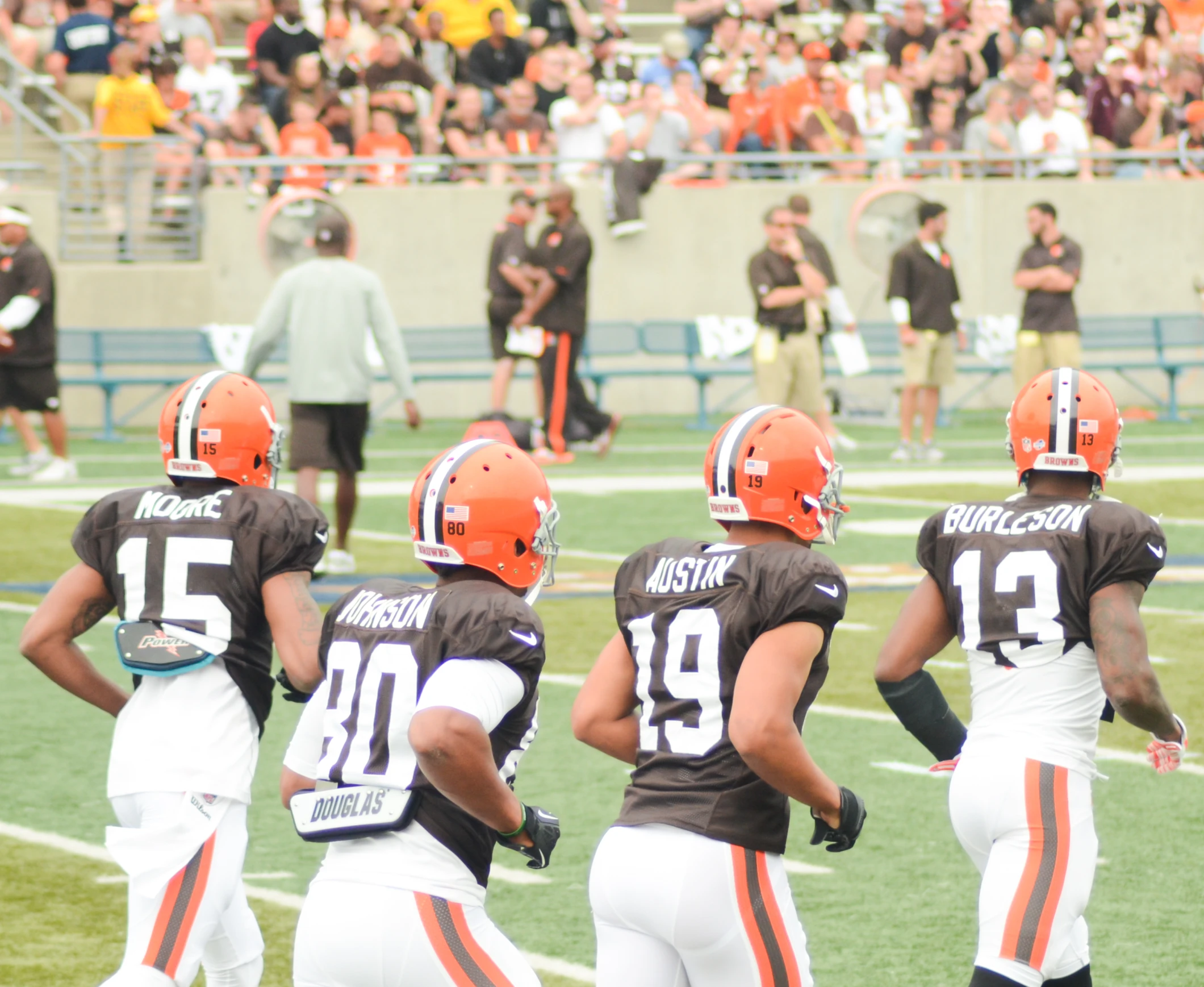 several browns football players stand together on the field