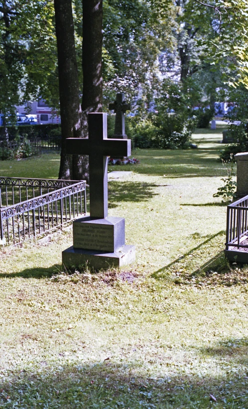 a cemetery bench sitting in a park surrounded by trees