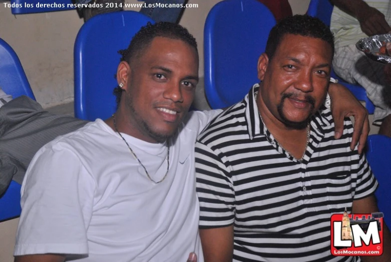 two men are posing for the camera inside a stadium