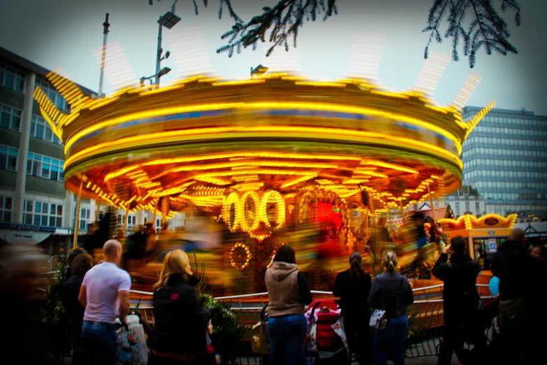 people standing near a merry go round on the street