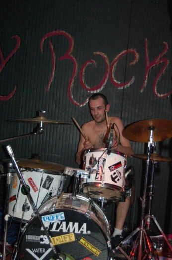 a man playing drums in front of graffiti on the wall
