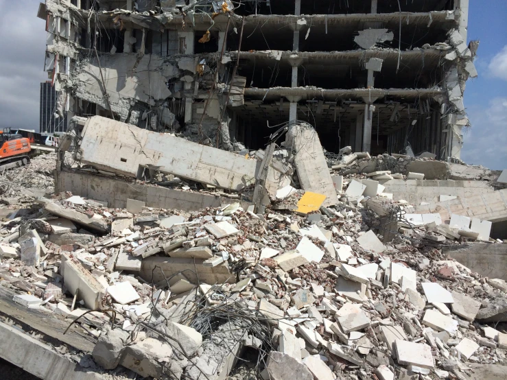 large construction area with pile of rubble and construction vehicles