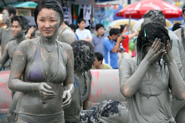 two young ladies covered in mud and mud