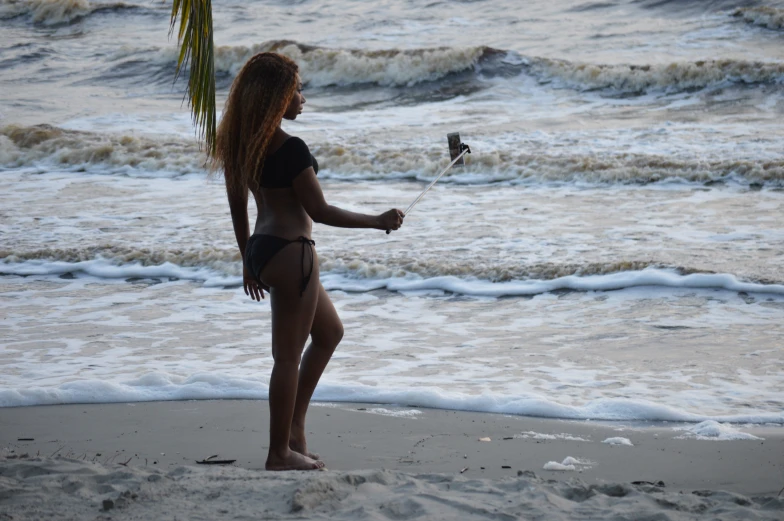 woman with wetsuit on standing in water near shore