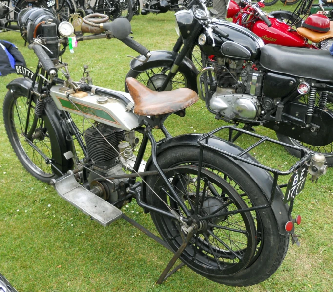 a group of motorcycles parked next to each other on a lush green field