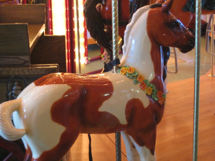 a red and white toy horse on top of a wooden floor
