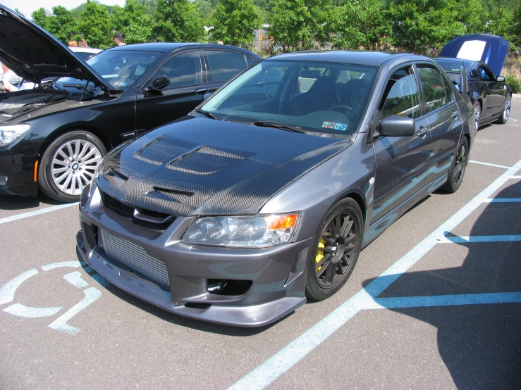 two cars parked in parking lot next to each other