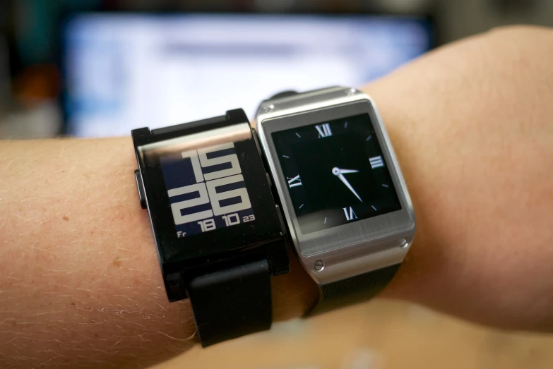 a person holding their arm up with a small smart watch on their wrist
