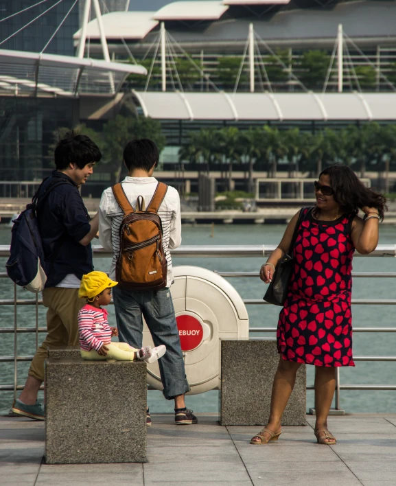 a group of people standing next to each other on a sidewalk