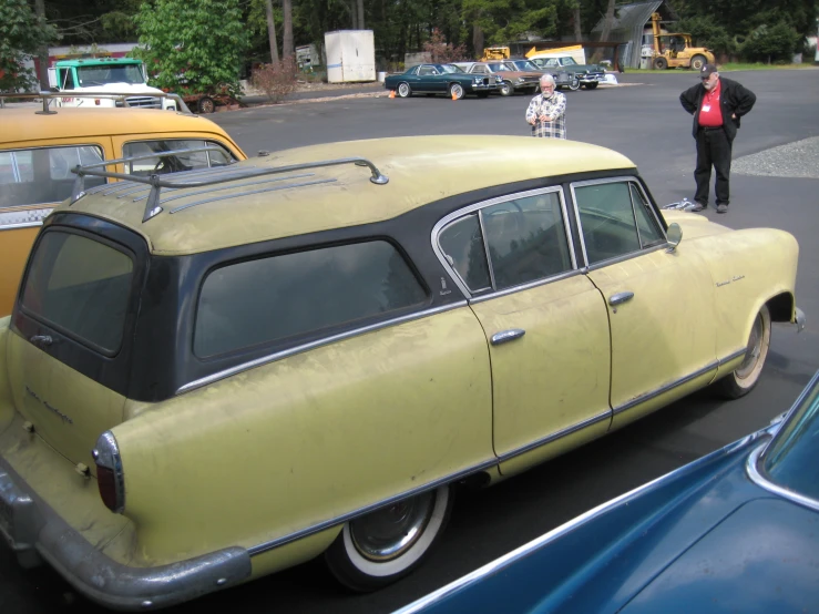 a very old fashion car sits in a parking lot