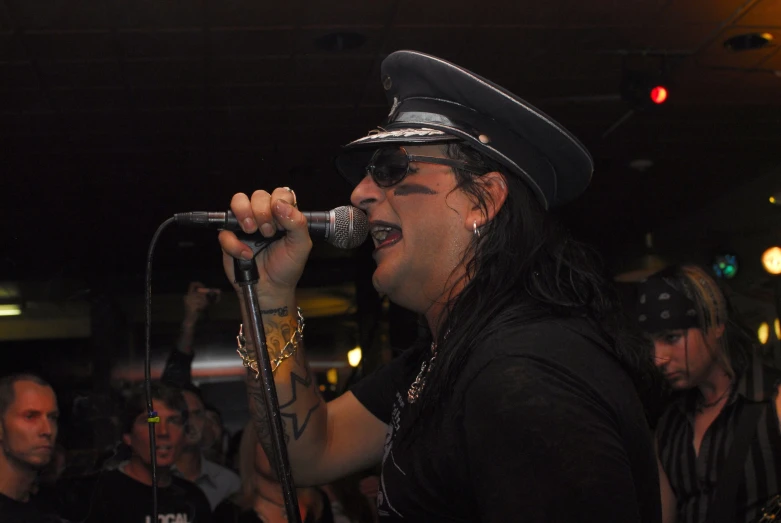 a man in a black hat holding a microphone