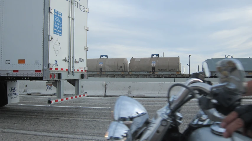 a motorcycle is parked near some cargo containers