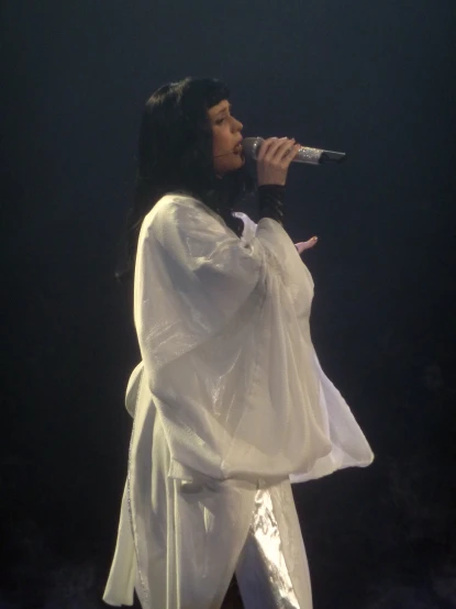 she is in an all white outfit, singing