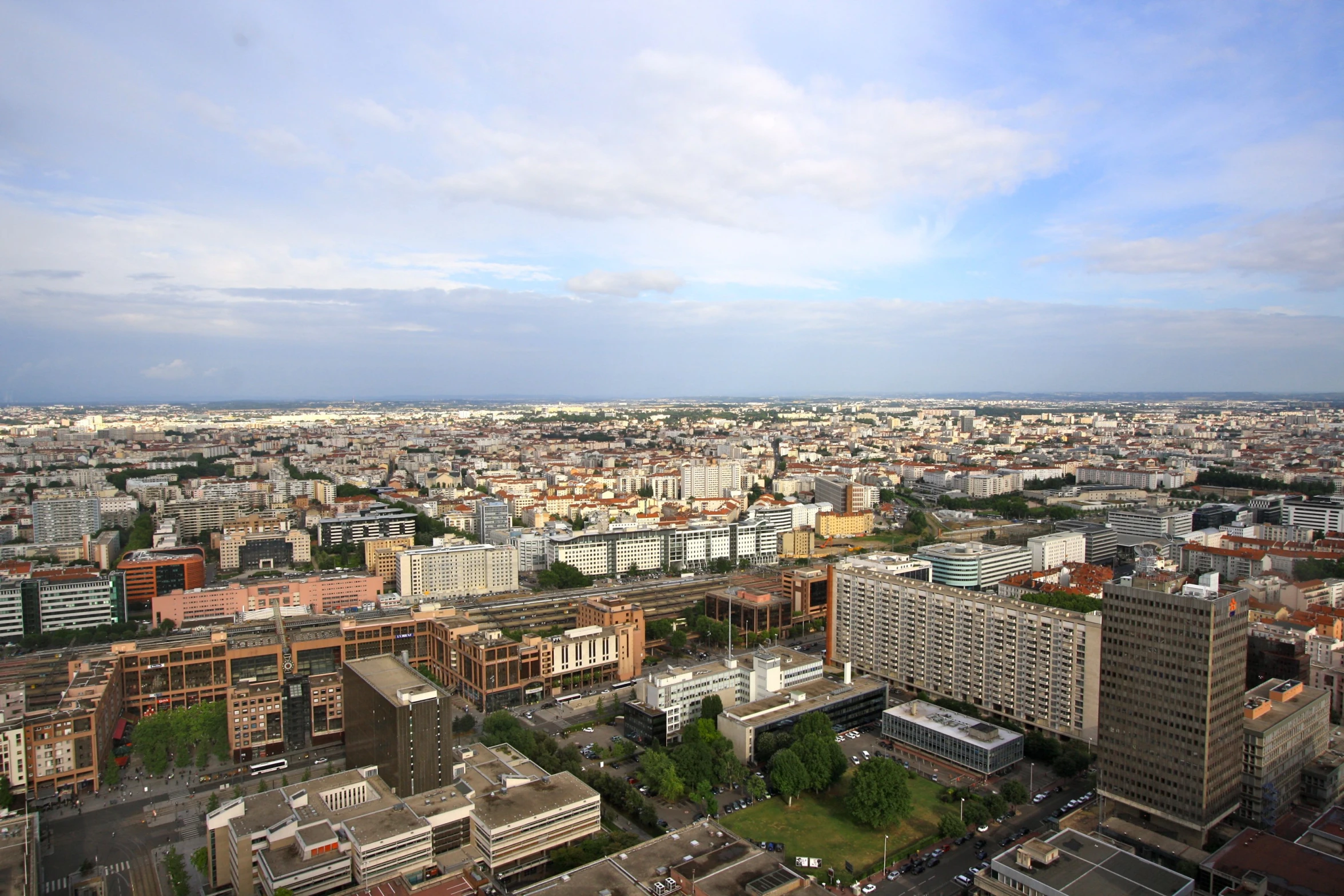 the city with lots of tall buildings and green trees