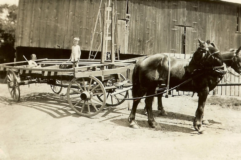 an old po of two boys and a horse in front of a barn