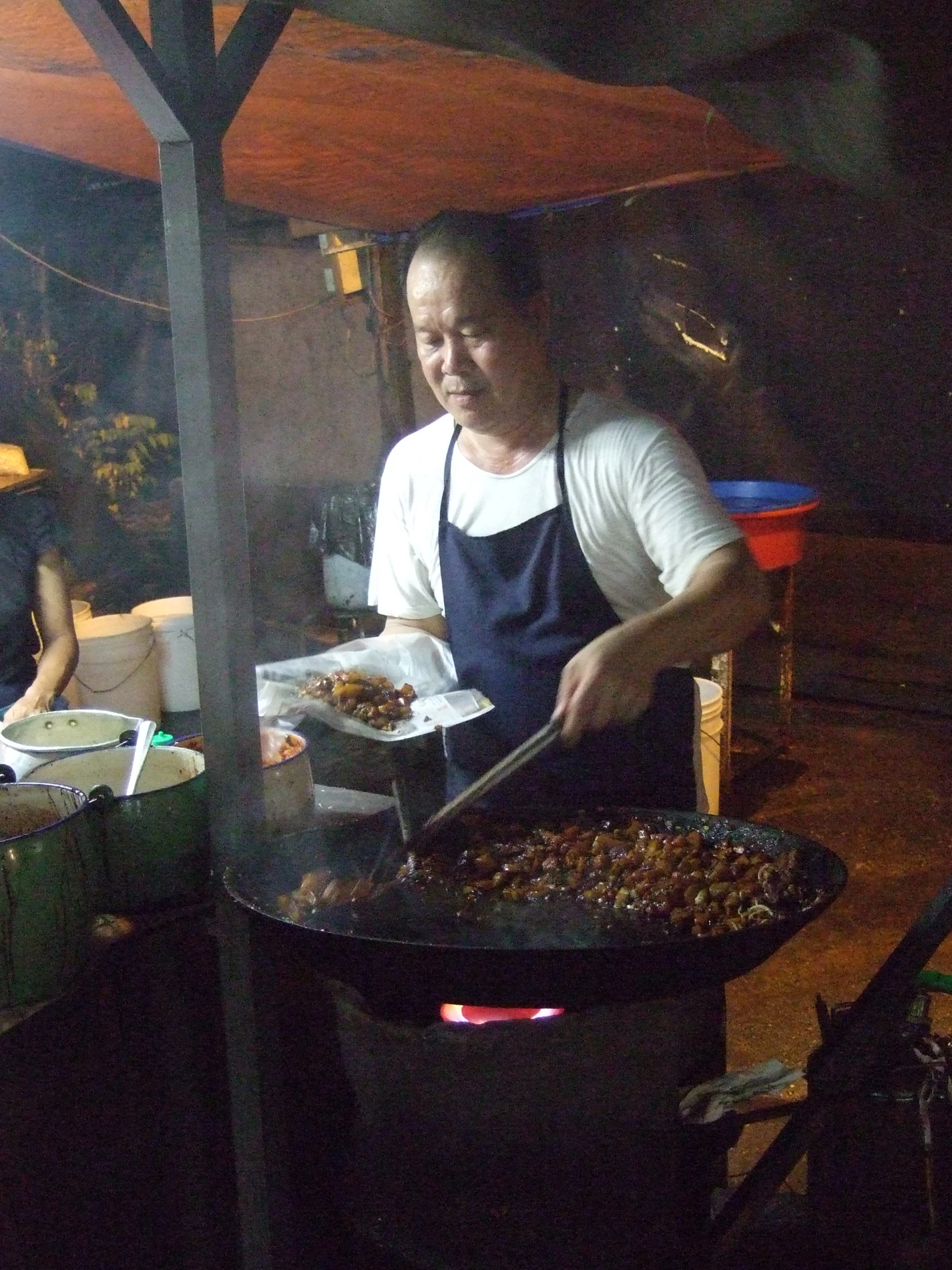 a man in an apron cooking a big plate of food