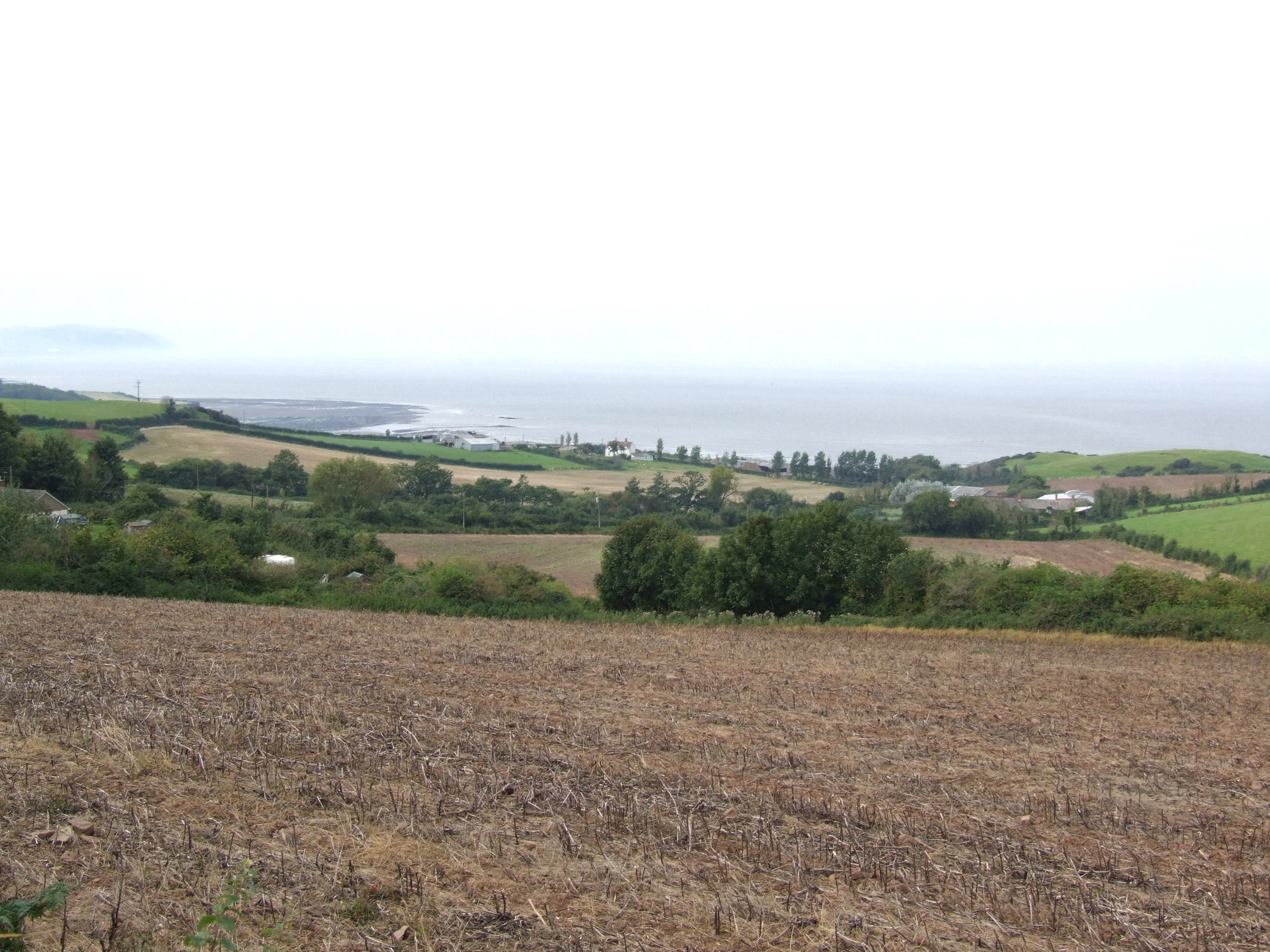 a plowed field on the edge of a country side