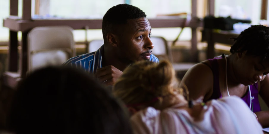 a man in a white shirt talking to two children