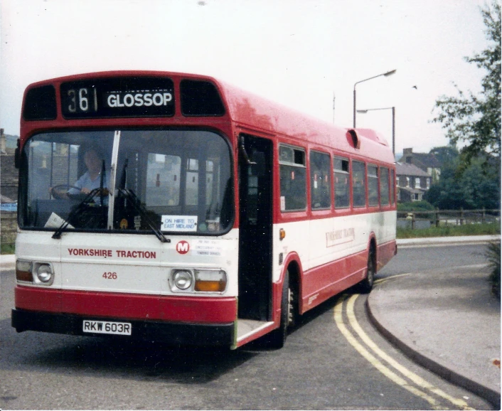 a large red and white bus on a city street