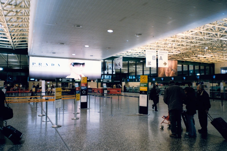 people walking around at an airport near large check in counters