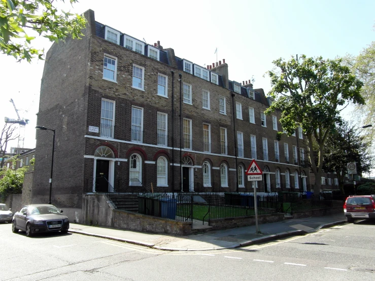 a brown building with white shutters near a street