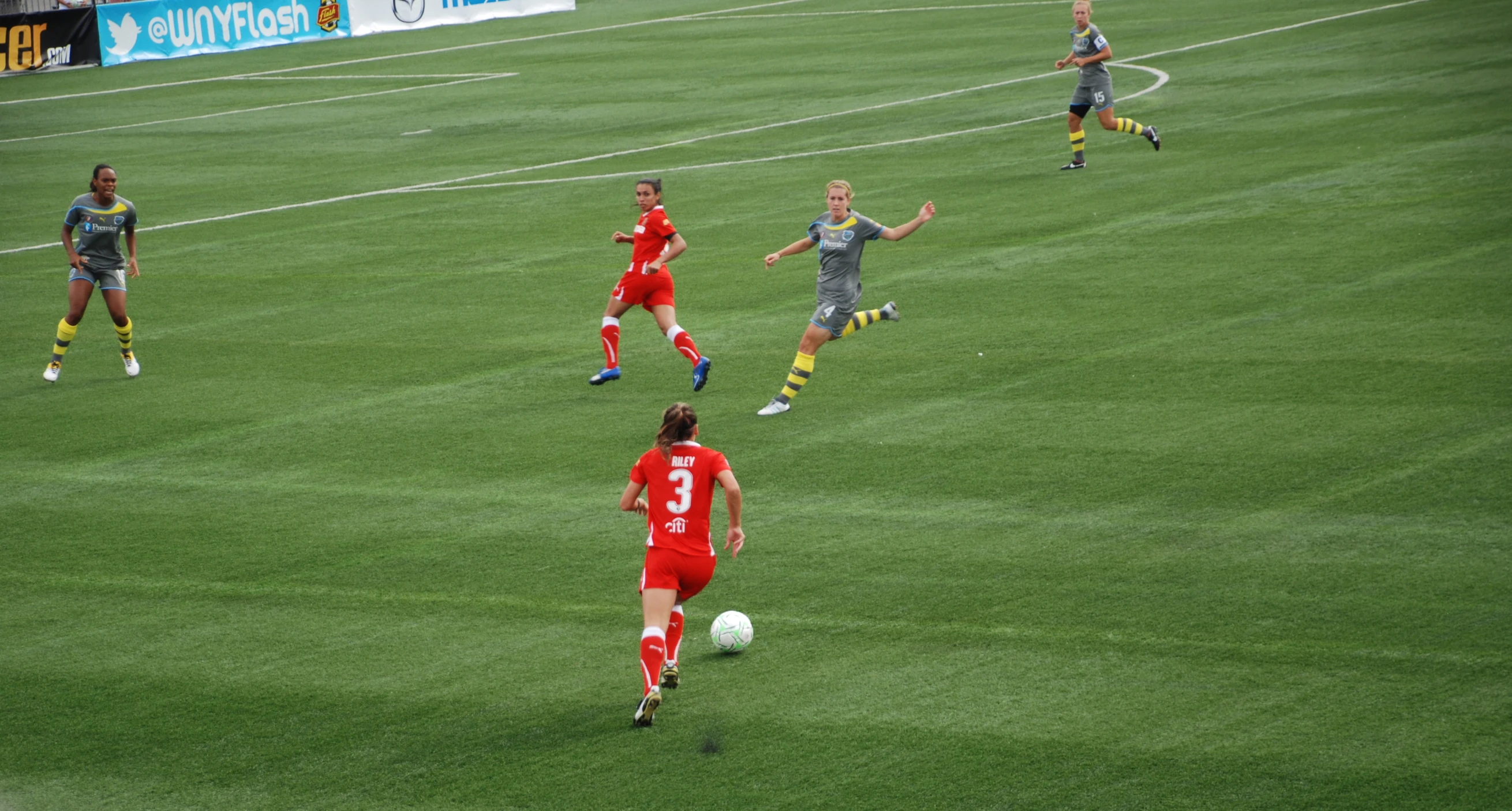 people on a field playing soccer on a sunny day