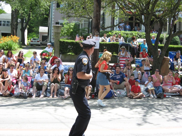 a police officer is walking down the street during a parade