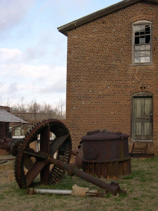 an old wooden wheel next to a building