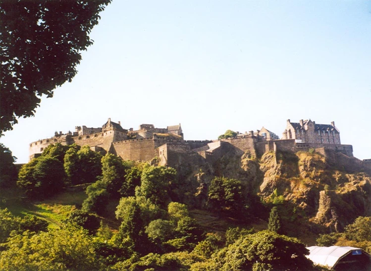 a large castle sitting on top of a lush green hillside