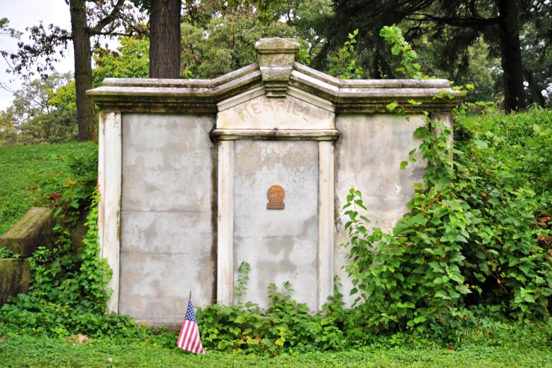 a grave sits in the middle of some greenery