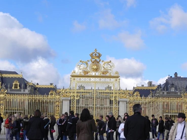 several people are standing outside in front of a palace