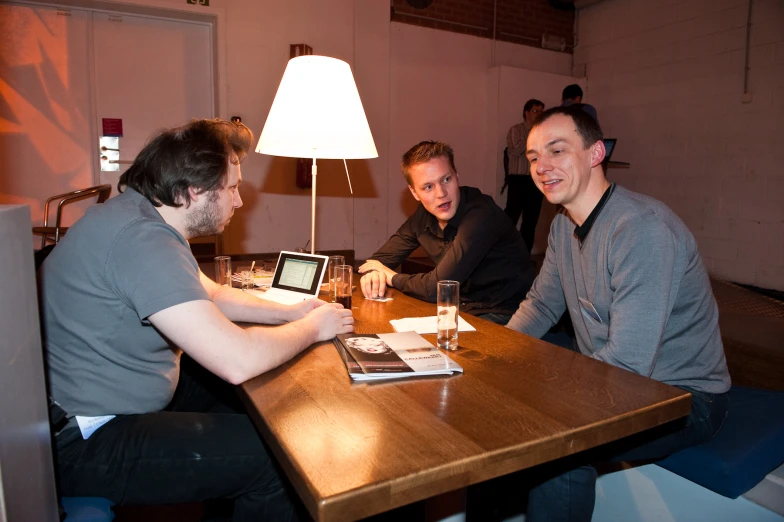 four men are sitting at the table and enjoying drinks