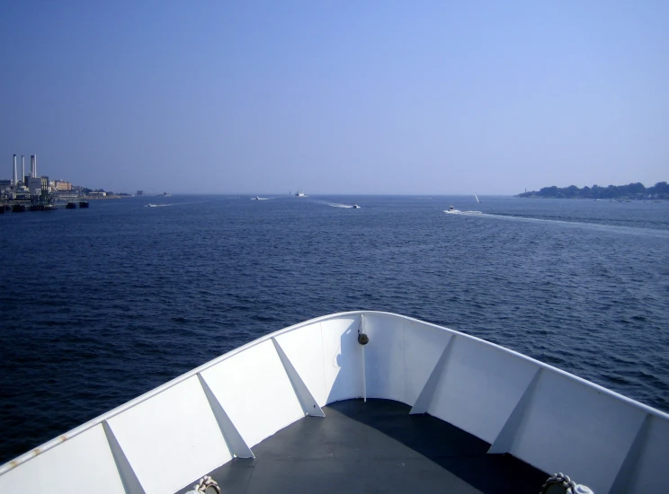 an outboard view of the ocean with boats traveling in the distance